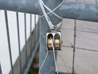 Double brass pulley attached to railing using polypropelene twine