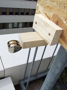 Double brass pulley attached to mounting block on railing